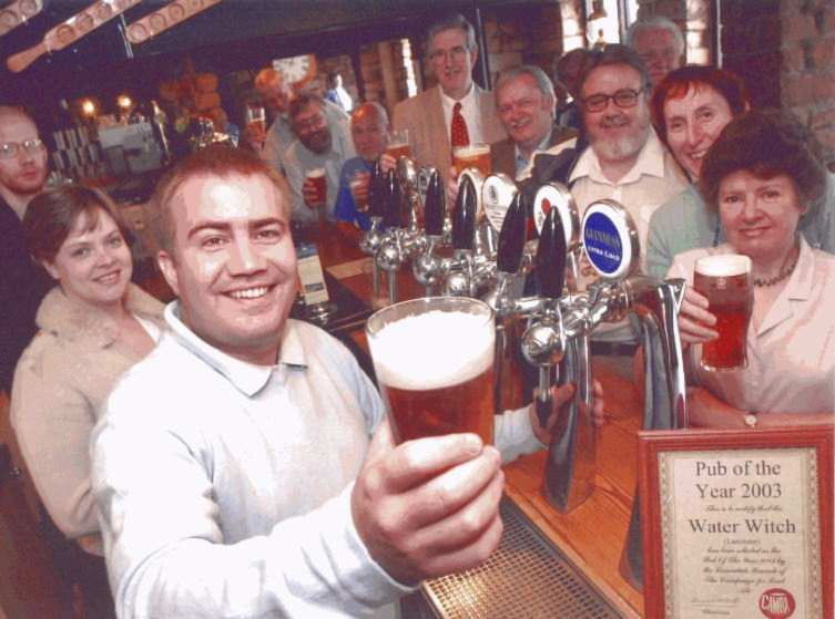 Matt Jackson (front), proprietor of the Water Witch, being presented with his Pub of the Year award by members of this branch (behind bar).
